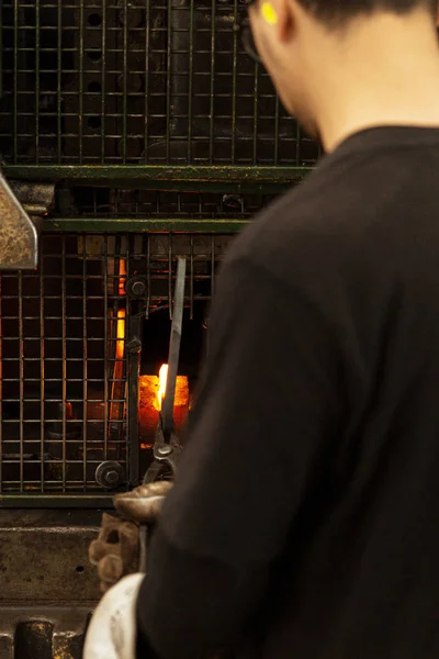 Herrero tocando la barra de acero en su lugar con maquinaria de fabricación — Foto de Stock