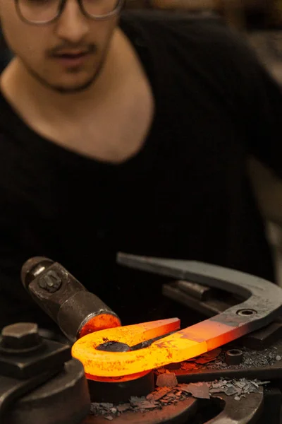 Herrero tocando la barra de metal caliente en perfecto gancho — Foto de Stock