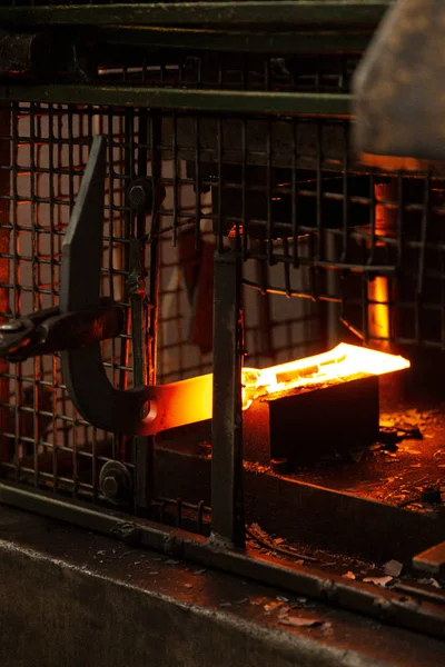 Barra de metal caliente ardiente que está siendo aprovechada en forma por el fabricante de metal — Foto de Stock