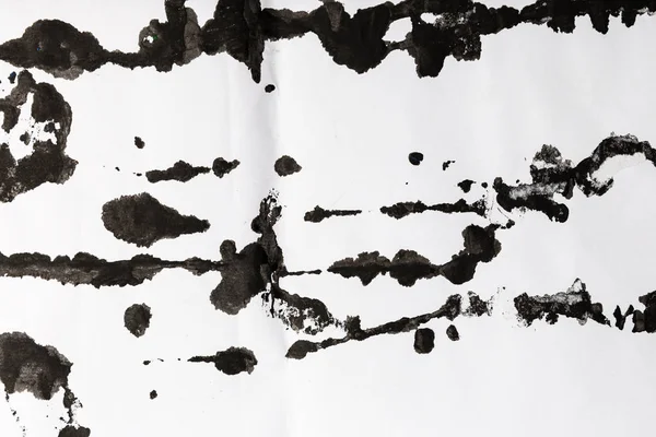 Zwarte inkt spetter loopt op wit papier — Stockfoto