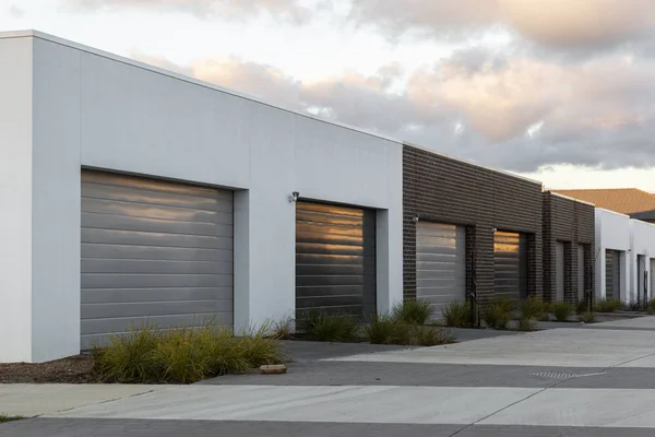 Garajes modernos que reflejan la luz dorada de la tarde en el área suburbana — Foto de Stock