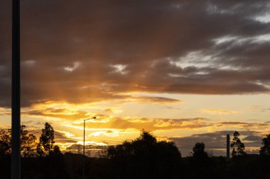Güneş ışınları kışın öğleden sonra alçak bulutlarda parıldıyor.