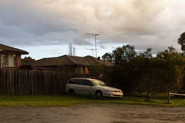 Terk edilmiş beyaz araba, banliyöde terk edilmiş evler. — Stok fotoğraf