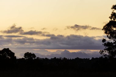 Gün batımında siluet ufuk çizgisinde yuvarlanan bulutlar