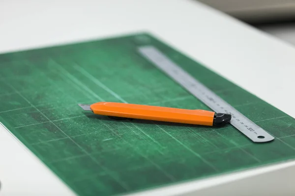 Paper Cutting Knife And Ruler On Cutting Board