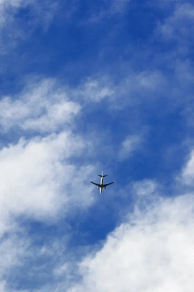 まともな雲の下を飛ぶ飛行機 — ストック写真