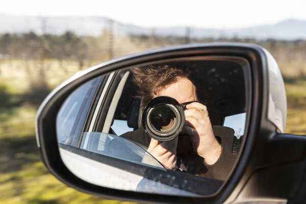 Man Taking Photo With Camera From Car
