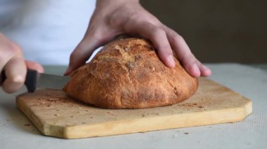 Şef fırıncı taze İtalyan ekmeği keser.