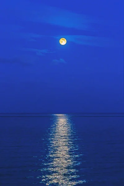 Luz de la luna llena sobre un mar tranquilo durante la noche — Foto de Stock