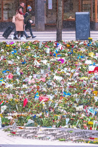 Família passando pelo canteiro de flores em queda de neve em Sergels torg afte — Fotografia de Stock