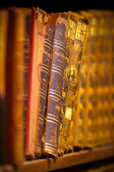 Alte goldene Bücher in den Regalen mit geringer Schärfentiefe bei th — Stockfoto
