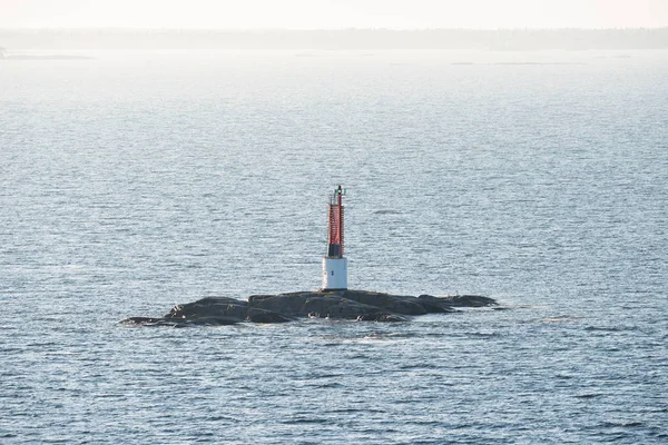 Rotes Leuchtfeuer auf einem kleinen Felsen am Meer — Stockfoto