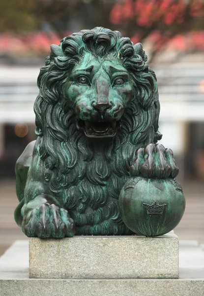 Vista frontale di una scultura in bronzo di un leone reale con le zampe o — Foto Stock