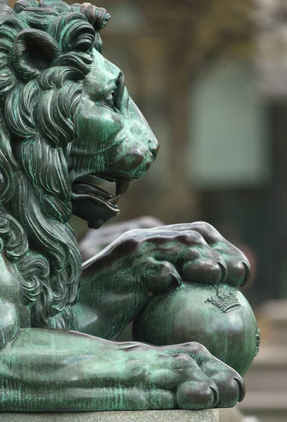 Side view of a bronze sculpture of a royal lion with the paws on — Stock Photo, Image