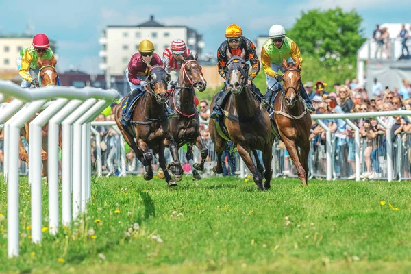 Koně s žokeji mimo křivku v rychlém tempu, na Nationaldagsg — Stock fotografie