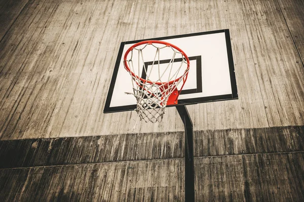 Arco de basquete cercado com concreto cinza em uma área áspera — Fotografia de Stock