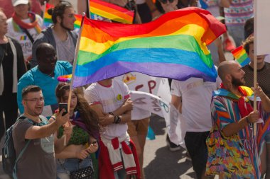 Waving rainbow flag at the pride parade in Stockholm with happy 