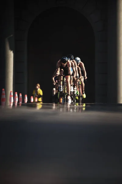 Grupp av triathleter långt borta på cykel med reflektioner i den — Stockfoto