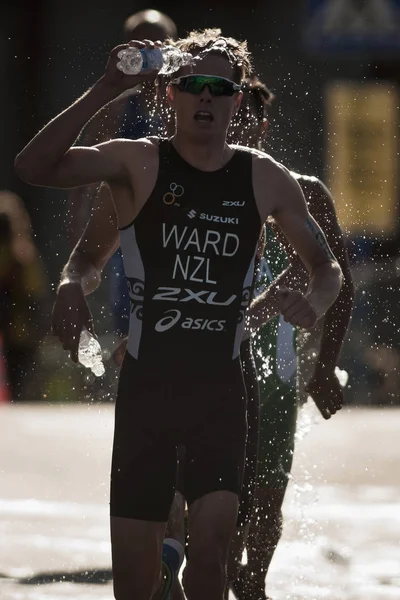 Arka ışık su istasyonu üzerinden çalışan triatlon koşucu