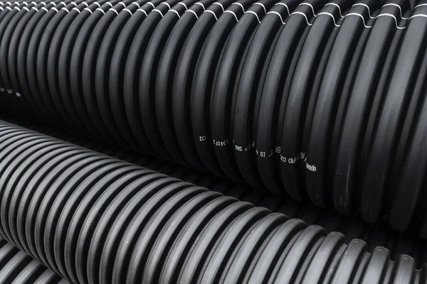 Black PVC plastic pipes in a pile during construction — Stock Photo, Image