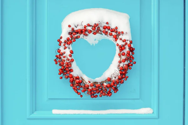 Kranz in roten Vogelbeeren auf der cyan Haustür bedeckt mit sn — Stockfoto