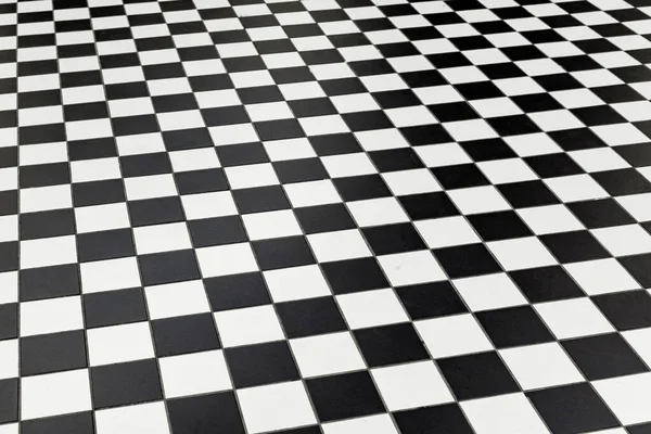 Checkered black and white floor tiles at a public station in per