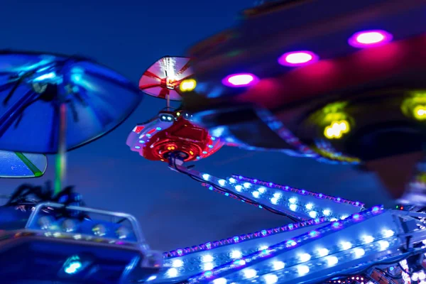 Kolorowa przejażdżka w parku rozrywki w nocy z rozmyciem ruchu — Zdjęcie stockowe