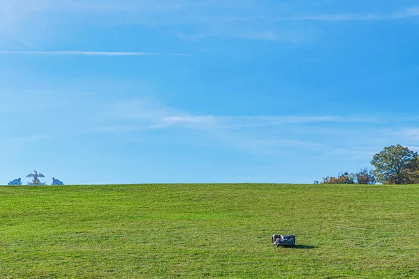 A lonely automatic electric lawnmover working thru the wast area — Stock Photo, Image