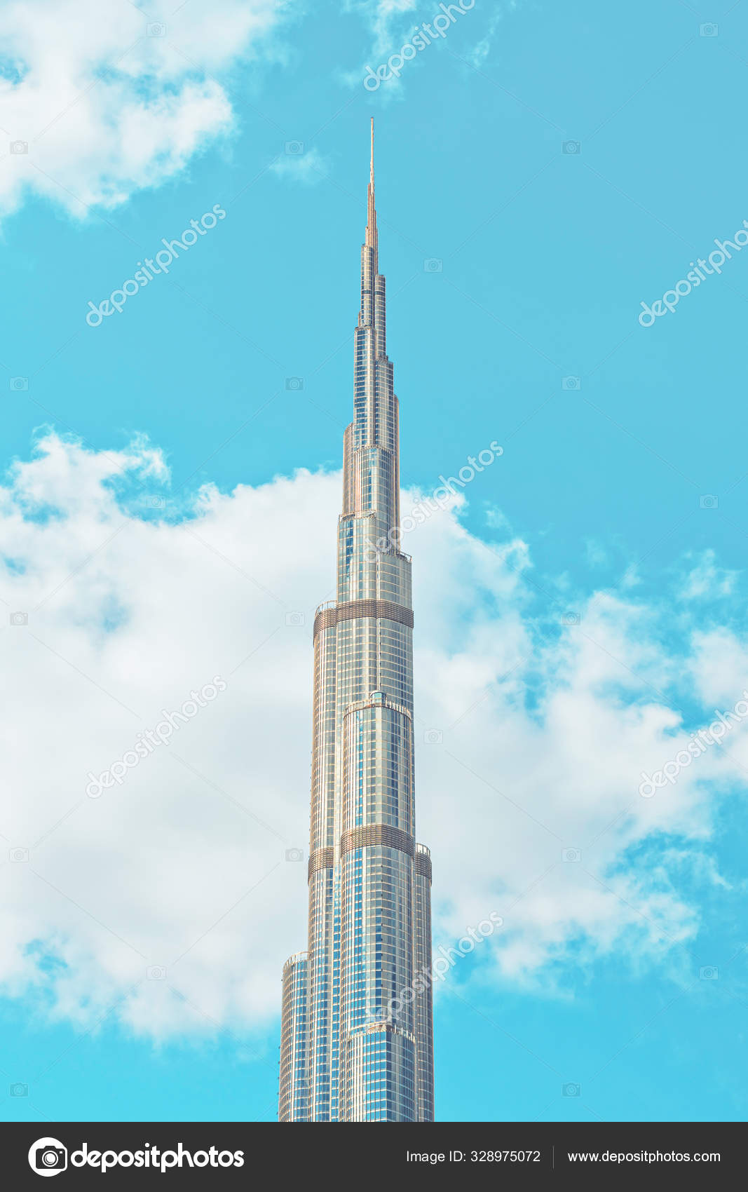 Burj Khalifa skyscraper peeking up in the white clouds with blue ...