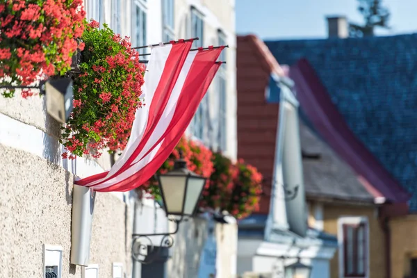 Bright facade of a residential house with red colorful flowers a — Stock Photo, Image