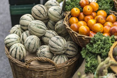 Küçük kavunlu sepetler ve pazarda satılık portakallar.