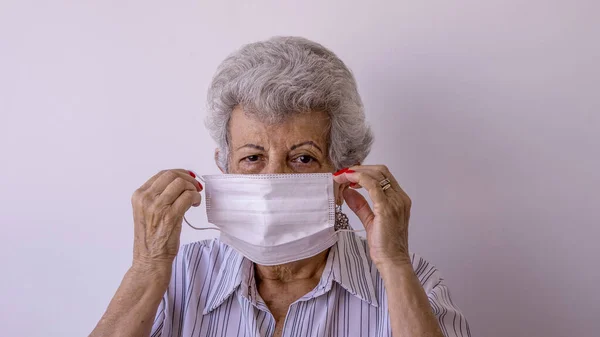 Corona virüsüne karşı koruyucu maske takan yaşlı kadın.