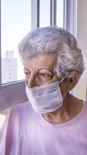 Corona virüsüne karşı koruyucu maske takan yaşlı kadın.