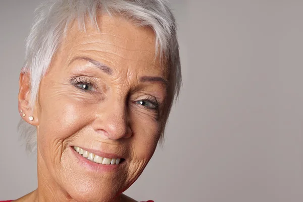 Nærstående eldre kvinne med toothy smil – stockfoto