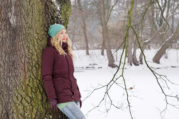 Zamyšlená žena opřený strom v zimě — Stock fotografie
