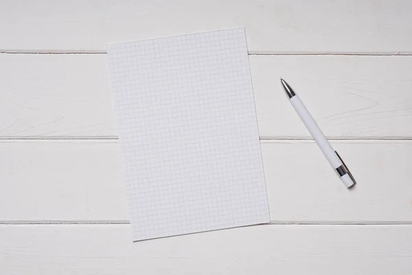 Papír a pero na bílý dřevěný stůl — Stock fotografie