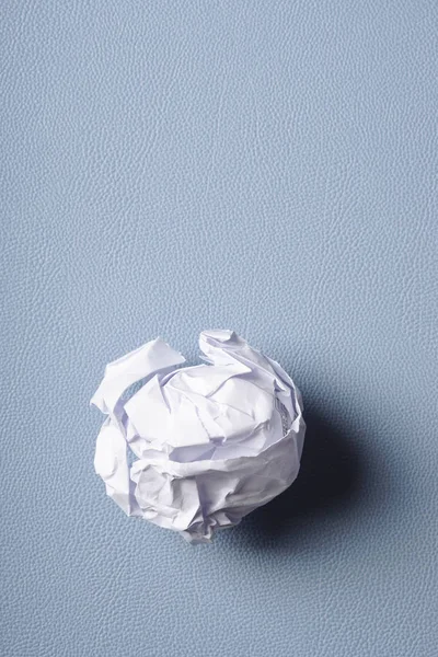 Мятый бумажный шар на синем фоне — стоковое фото