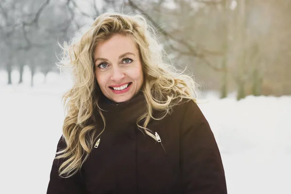 Mujer disfrutando de un paseo invernal por el parque cubierto de nieve — Foto de Stock