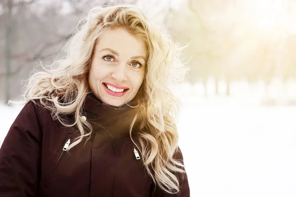 Блондинка в зимовому пейзажі з сонячним сяйвом — стокове фото