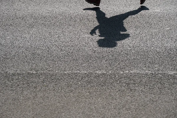 Ombre d'un coureur méconnaissable sur asphalte — Photo