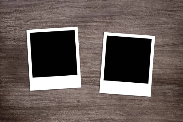 Два почерневших шаблона для мгновенной печати фотографий на деревянном фоне — стоковое фото