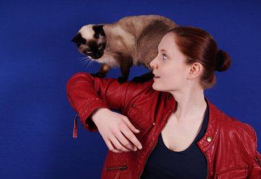 young woman playing with cat on her arm clipart