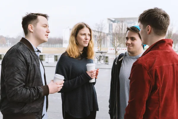 Grupo de amigos adolescentes teniendo una conversación mientras están juntos en la calle de la ciudad — Foto de Stock