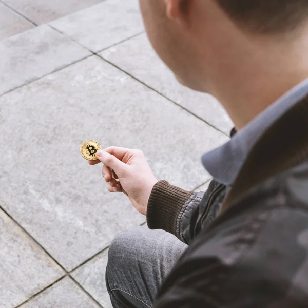若い男が彼の手で bitcoin コインを保持しています。 — ストック写真