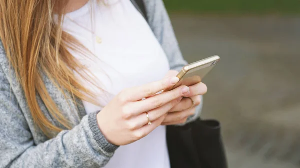 Oigenkännlig ung kvinna använder smartphone utomhus — Stockfoto