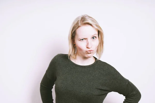 Skeptical young woman grimacing — Stock Photo, Image