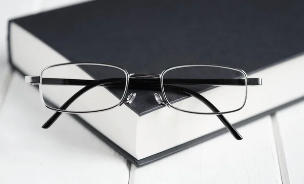 Läsglasögon ovanpå bok — Stockfoto