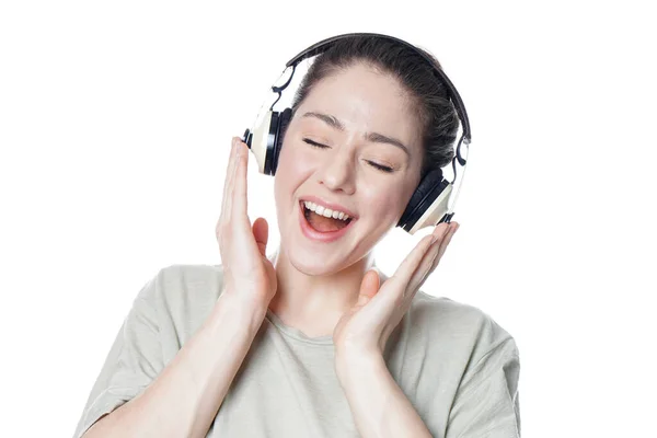 Счастливая молодая женщина в наушниках, подпевающая под музыку — стоковое фото