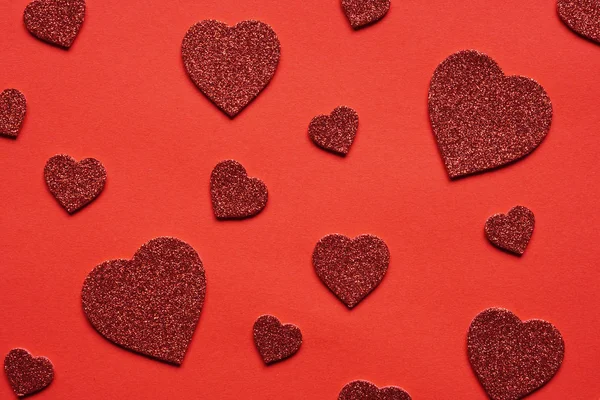 Amor temático fundo vermelho com vários corações glitter — Fotografia de Stock