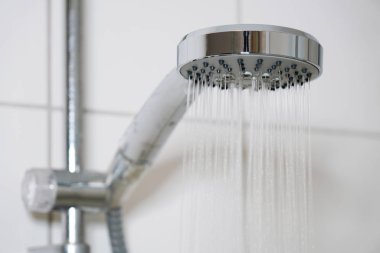 Modern duş başlığı ve akan su ile banyo.
